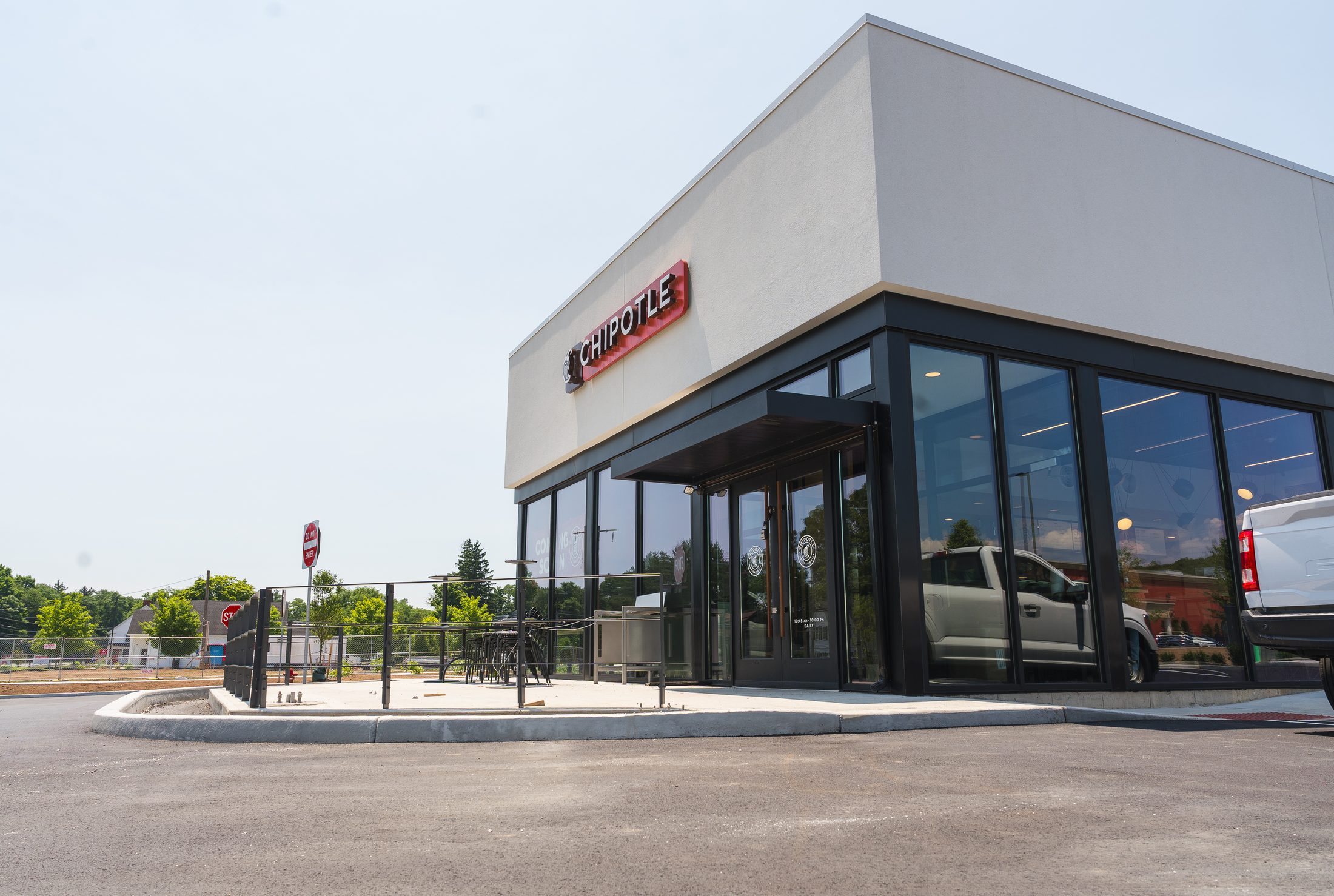 New construction Chipotle with black entrance canopy and glass storefront by Manchester Awning