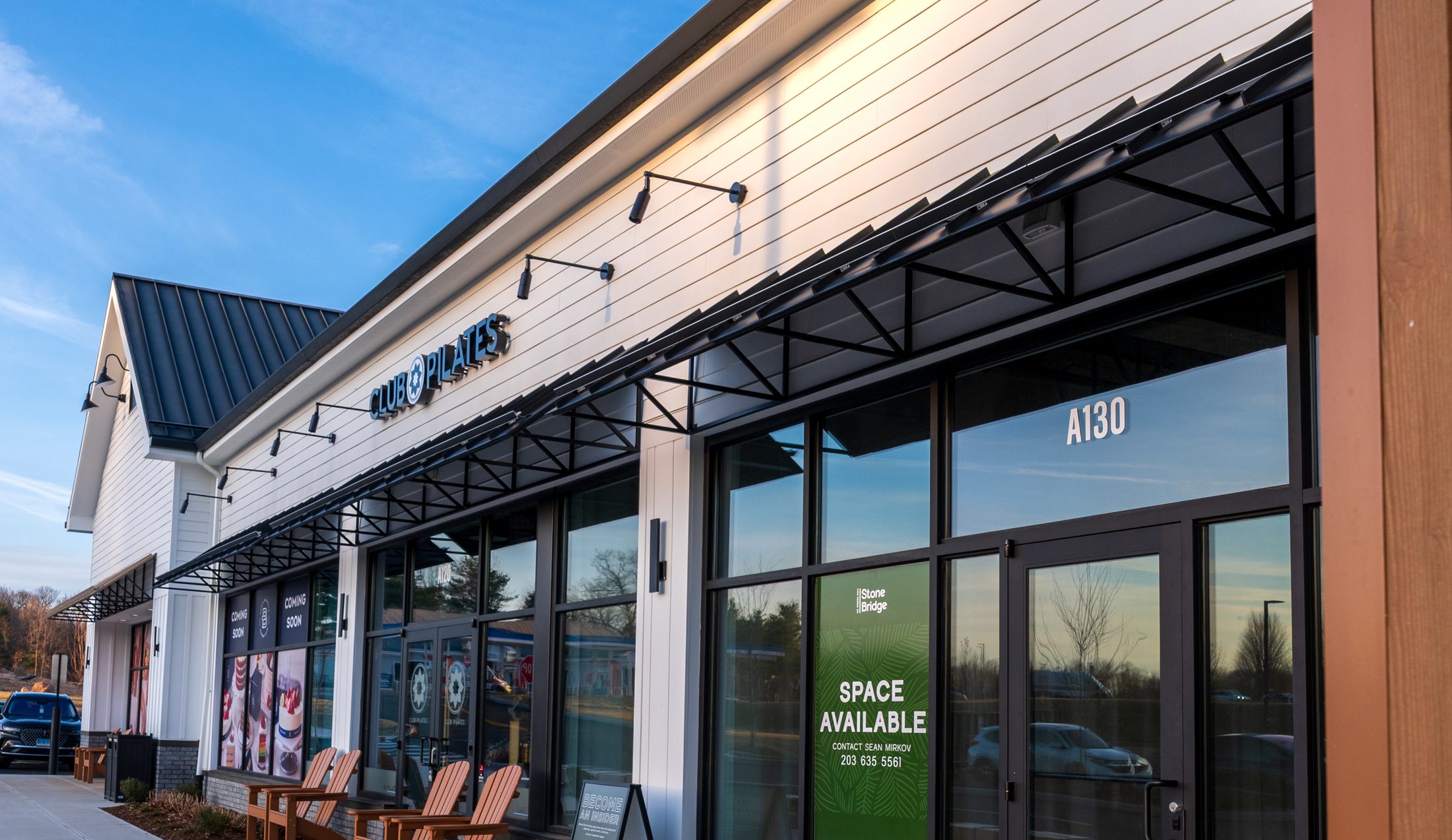 Black metal storefront awnings at Club Pilates by Manchester Awning