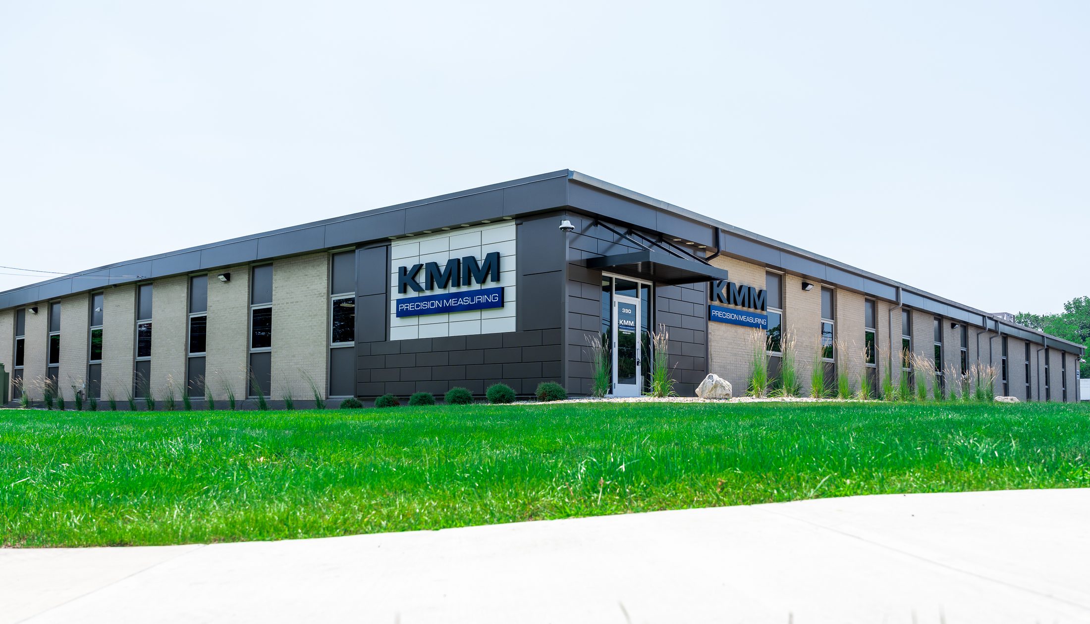 KMM Precision Measuring building corner with metal entrance canopies by Manchester Awning