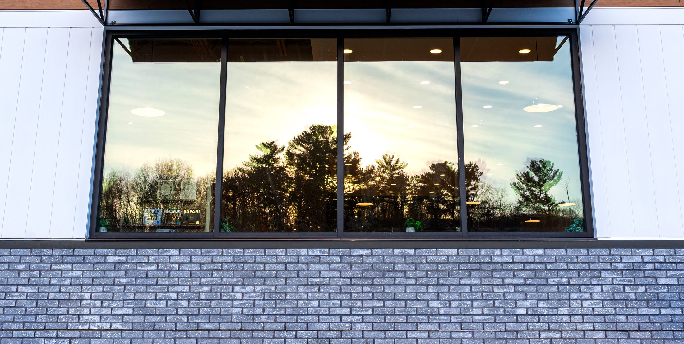 Black metal storefront window awning with sunset reflection by Manchester Awning