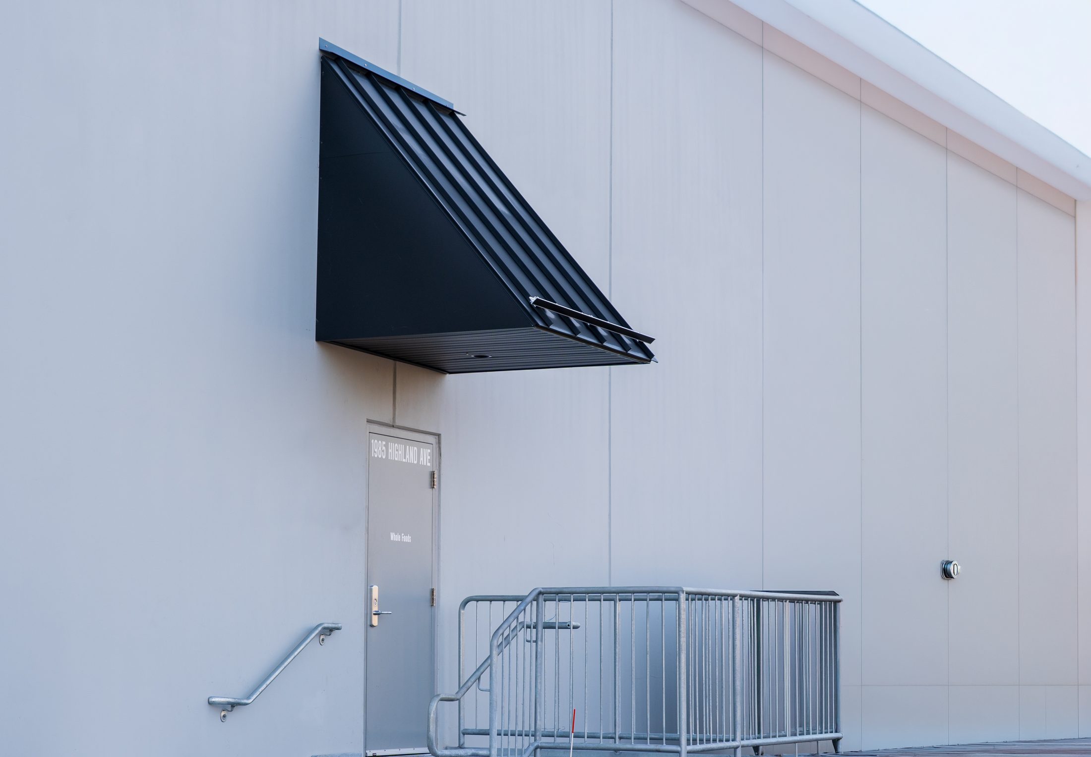 Angular black metal service entrance canopy at Whole Foods by Manchester Awning