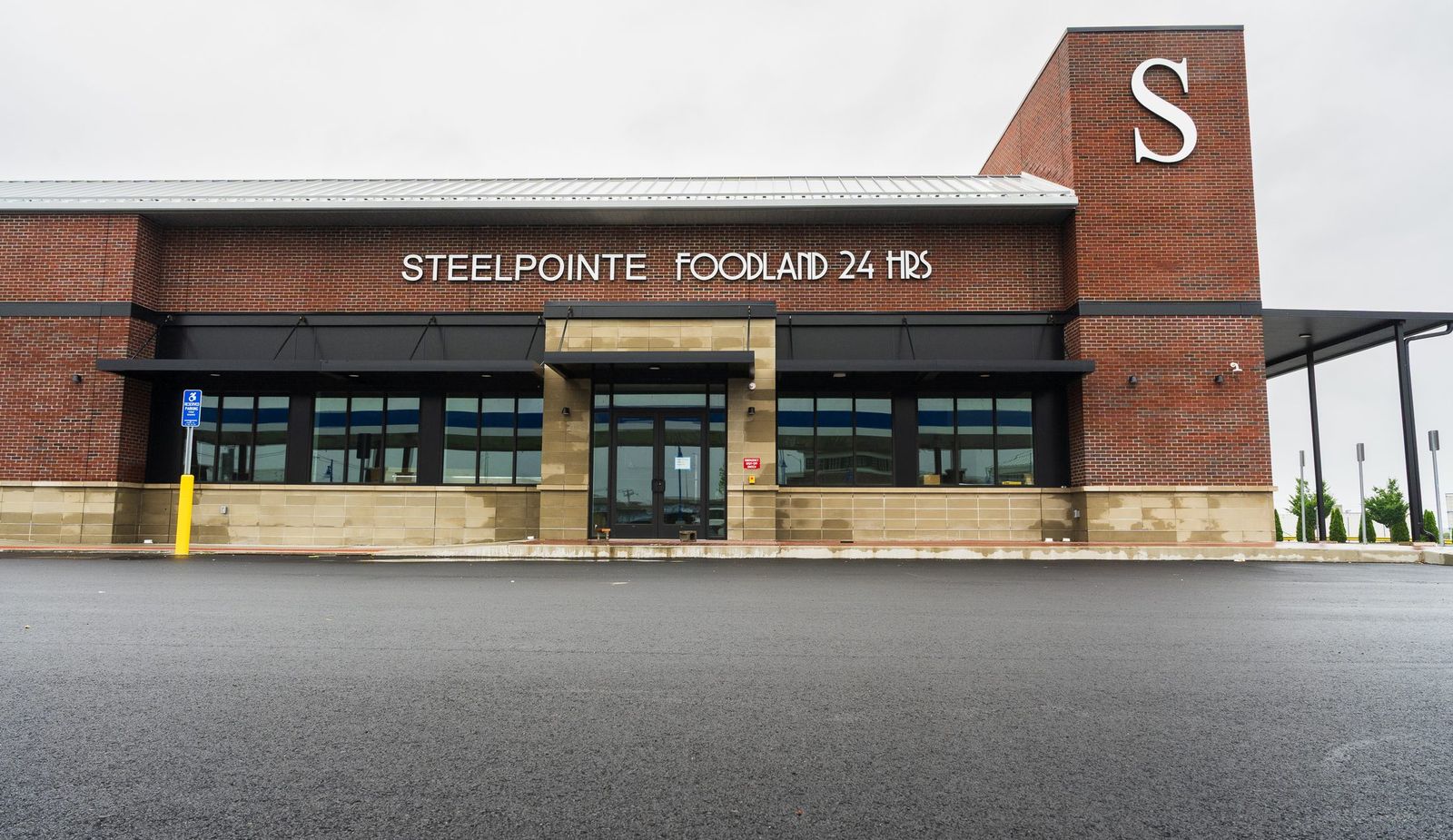 Full front elevation of Steelpointe Foodland showing the complete run of black metal awnings by Manchester Awning