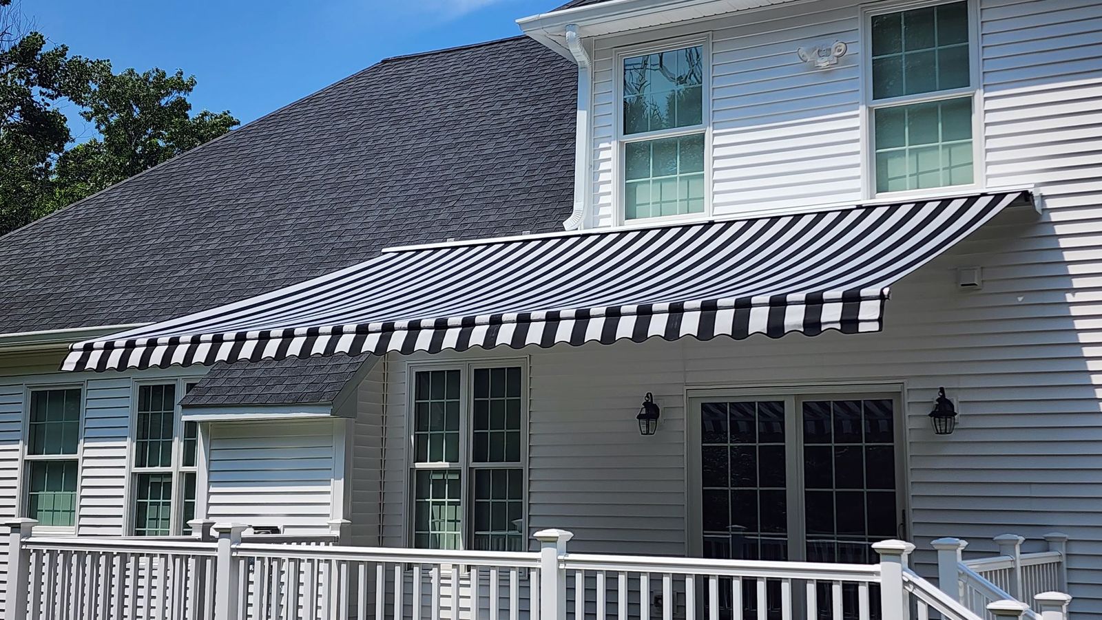 Legend lateral-arm retractable awning extended over a residential patio, arms fully open with no front posts