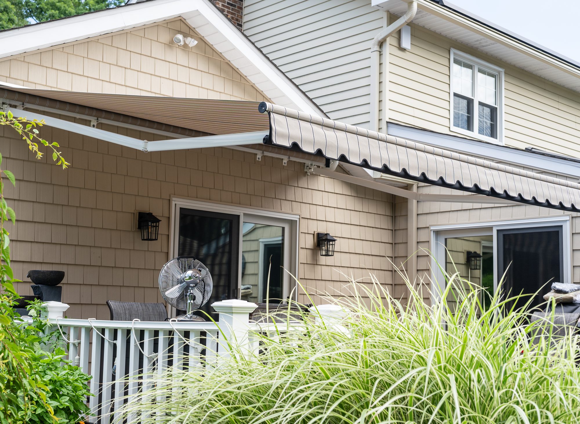 Striped retractable awning extended over a home deck by Manchester Awning