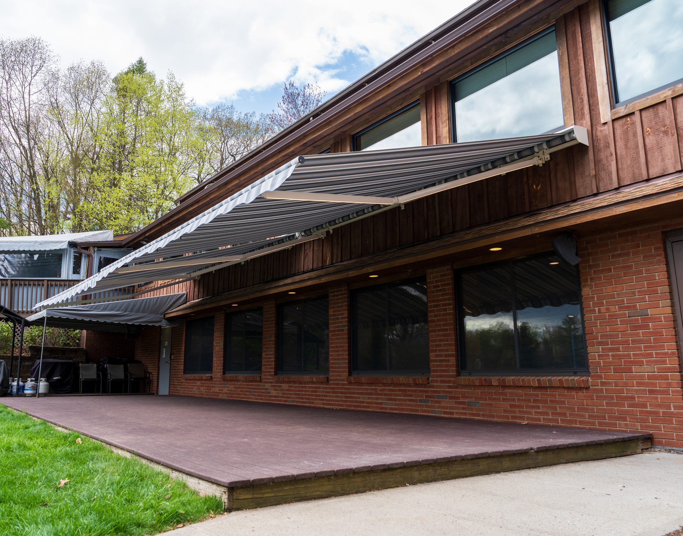 Retractable lateral-arm awning over a Connecticut deck by Manchester Awning