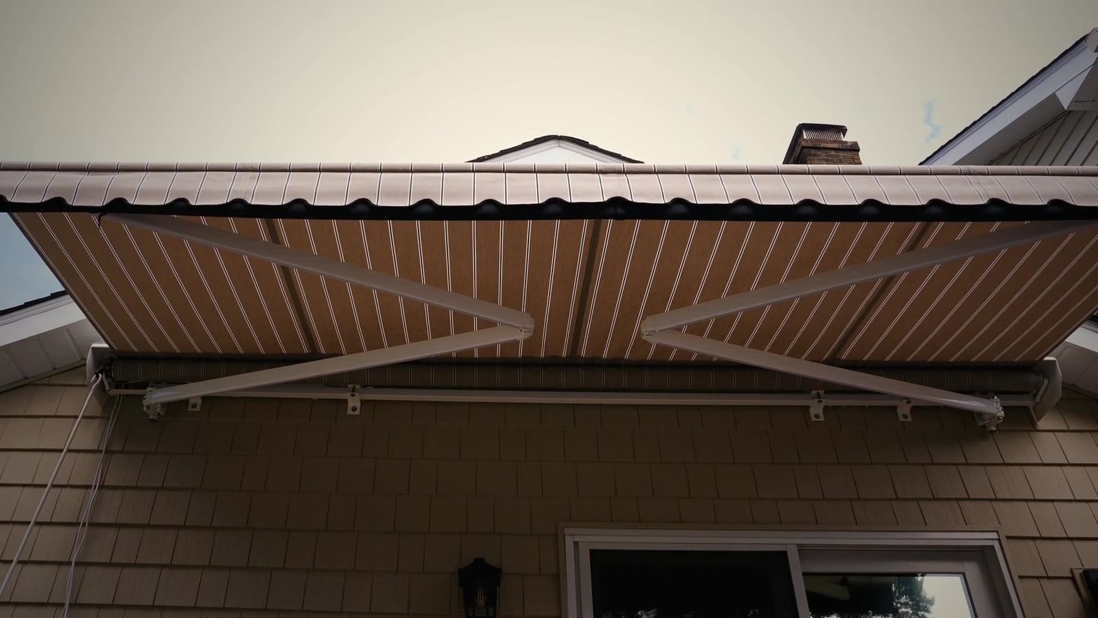 Legend lateral-arm retractable awning extended over a Connecticut home, built and installed by Manchester Awning