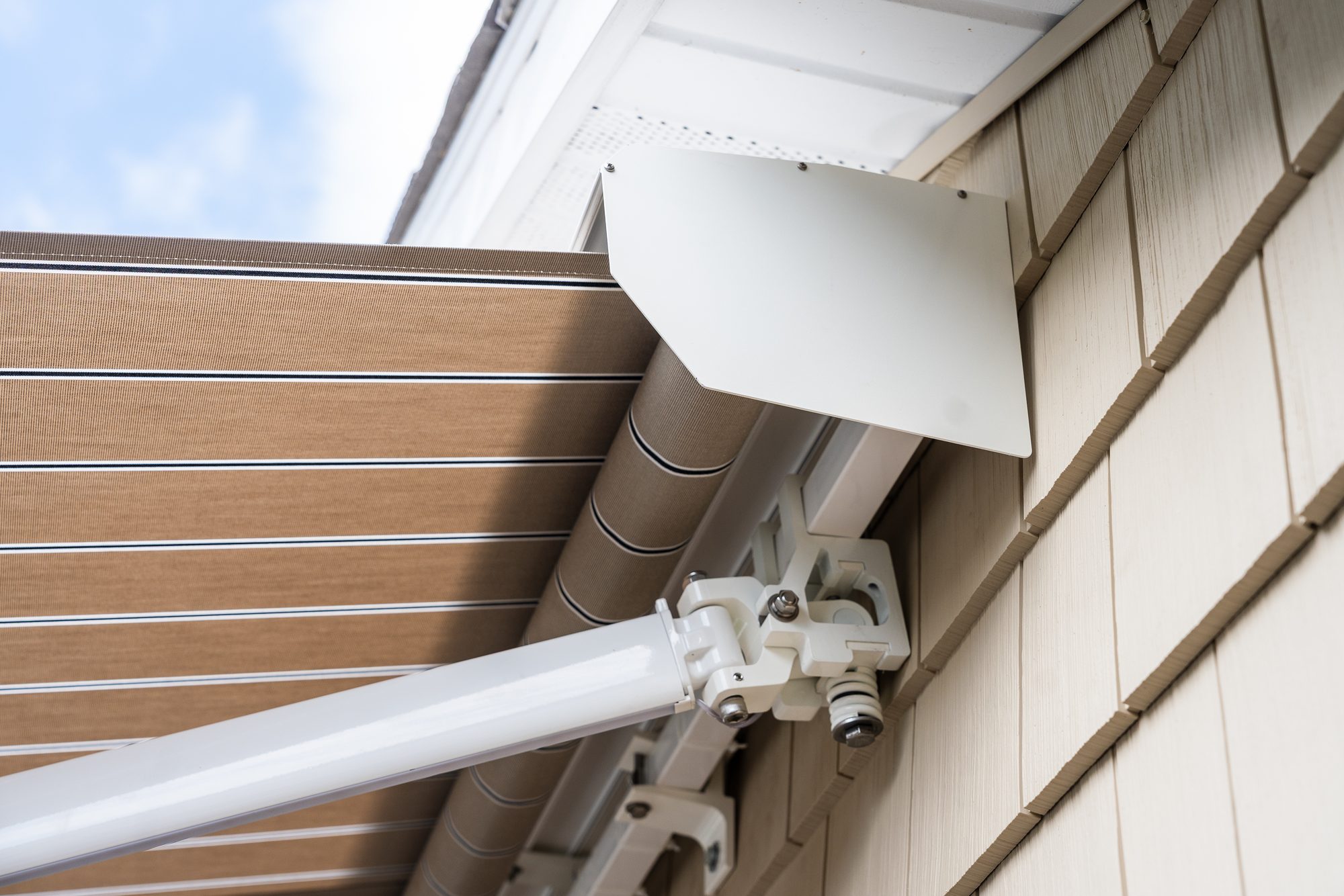Somfy sun sensor mounted beside a retractable awning arm on a Connecticut home by Manchester Awning